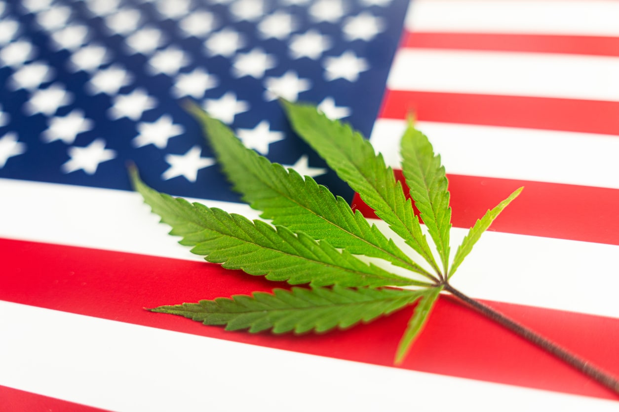 a hemp leaf on background of the American flag. Concept of legalization and changes in legislation regarding cultivation and use of marijuana in the country united states.