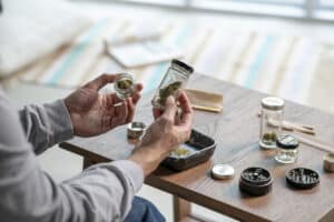 Young Asian man preparing marijuana at home.