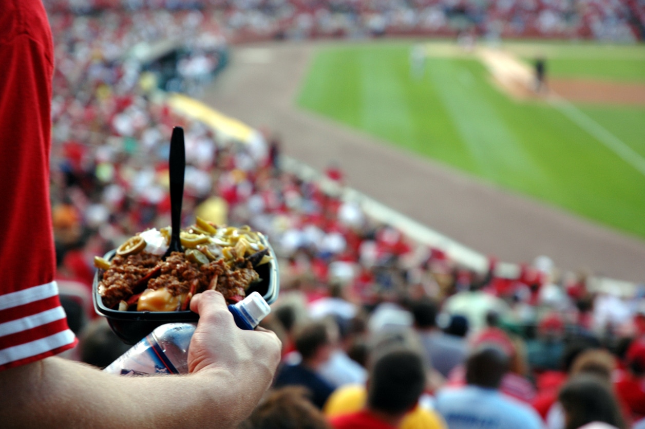A man makes his way back to his seat with a fist full of nachos.