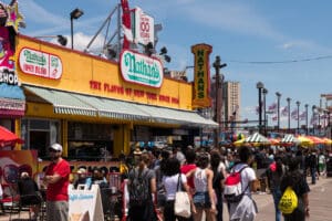 New York City, USA - June 4, 2019: People lined up at the Iconic Nathans Delicatessen on the boardwalk at Coney Island, in Brooklyn late in the day.