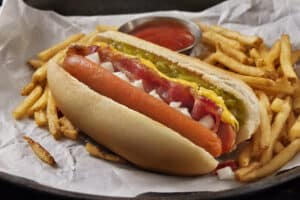 The Copycat Fast Food Restaurant Grilled Split Hot dog with Bacon, Sweet Relish, Onions, Cheese Sauce and Fries